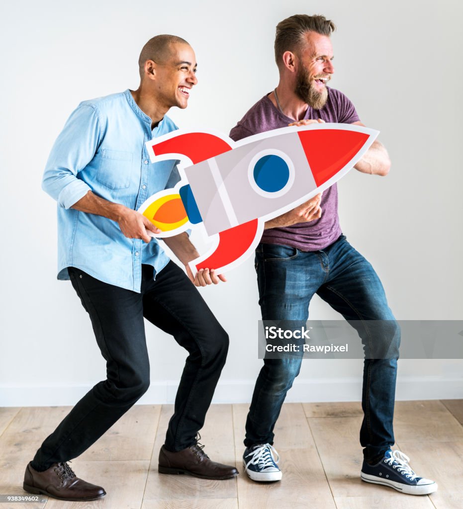 Friends holding a rocket icon Rocketship Stock Photo
