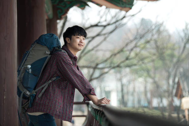 istock young man doing a backpacking trip in a Korean traditional house. 938349754