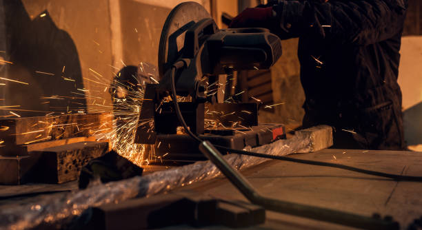 istock Professional hardworking man cutting or grinding metal surface on grinder machine and sparks at the factory of metalworking machining industry. 938349770