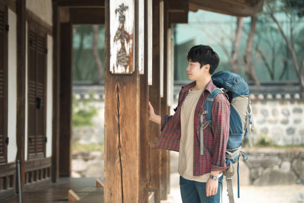 istock young man doing a backpacking trip in a Korean traditional house. 938349774