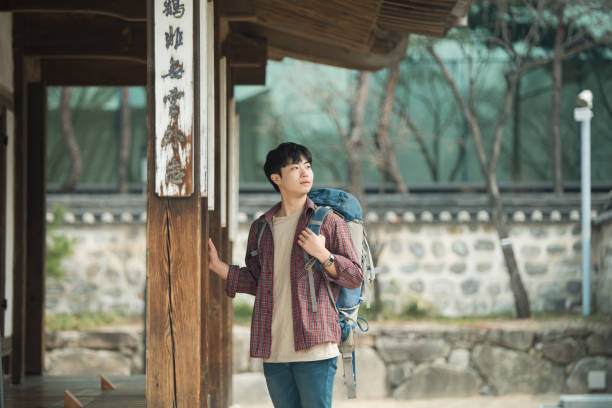 istock young man doing a backpacking trip in a Korean traditional house. 938349782
