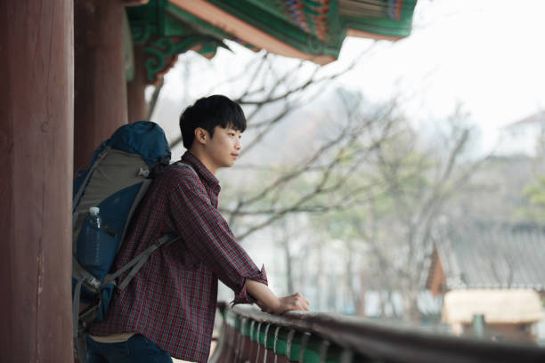 istock young man doing a backpacking trip in a Korean traditional house. 938349872