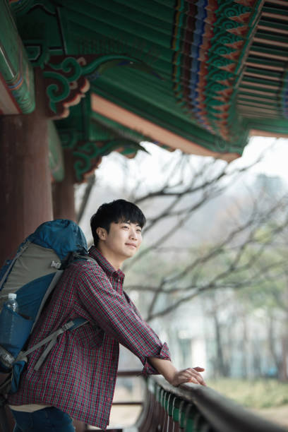 istock young man doing a backpacking trip in a Korean traditional house. 938349876