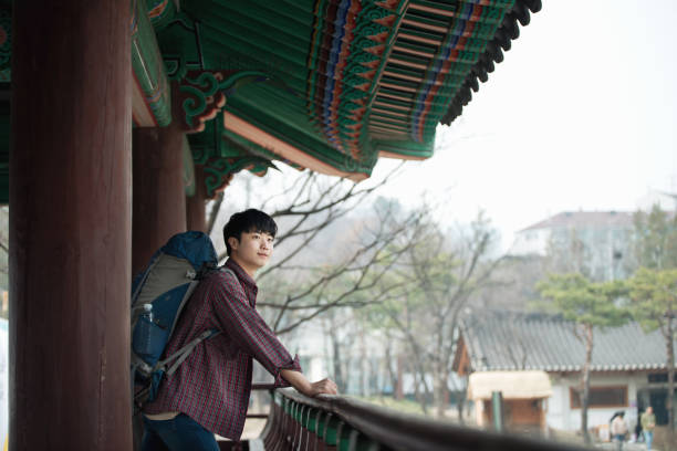 A young man doing a backpacking trip in a Korean traditional house.