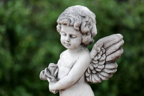 statue of an cute infant angel (cupid) with nature background
