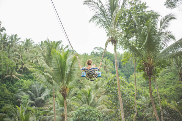 istock Young woman swinging over the jungle, Bali 938353530