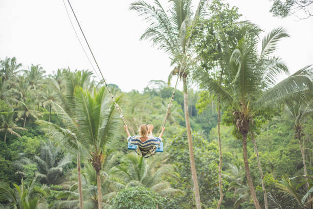 istock Young woman swinging over the jungle, Bali 938353532