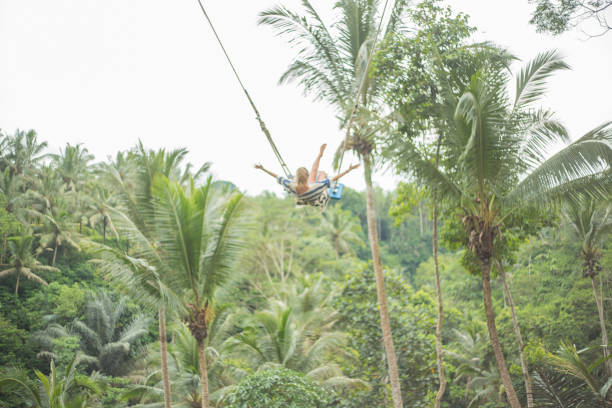 istock Young woman swinging over the jungle, Bali 938353576