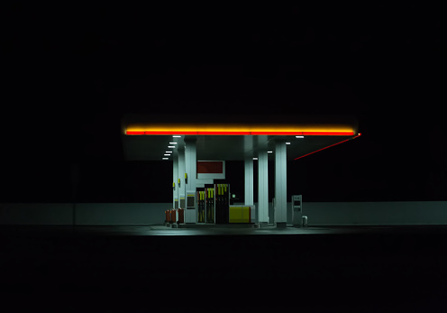 Illuminated gas station at night. Isolated on dark background.