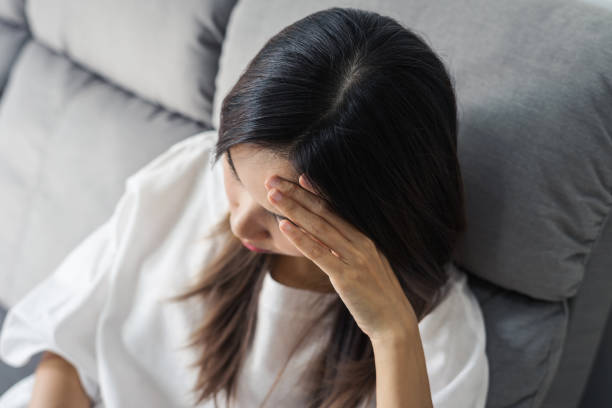 istock Depressed young woman holding hand on head 938360374