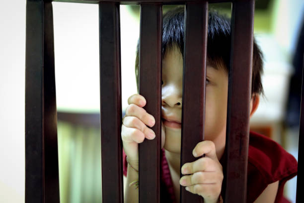 istock kid cute boy looking behind the chair 938364930