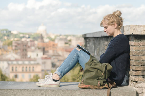16.10.2015 Young student girl reading an electronic book in the park. Rome, Italy stock photo