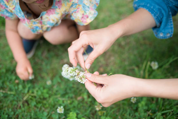 istock Mother and child making white clover's tiara 938379662