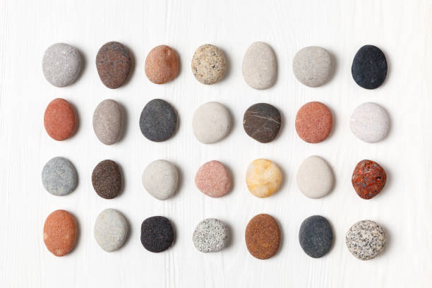 istock Pattern of natural multicolored pebbles on white wooden background. 938379826