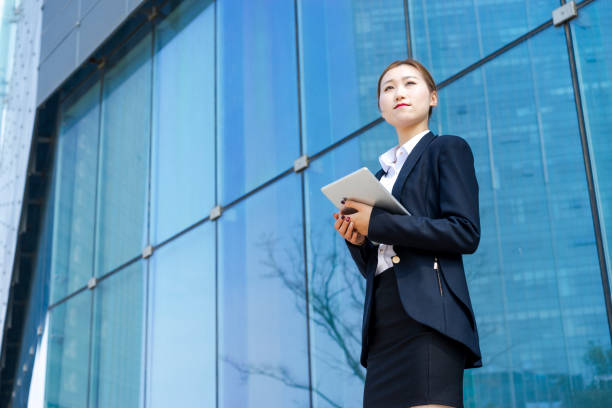 istock young business woman using tablet PC against glass wall 938388216