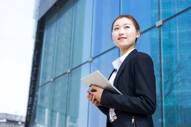 istock young business woman using tablet PC against glass wall 938388252