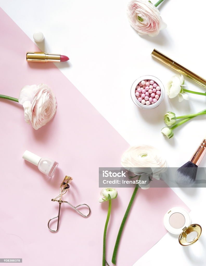 Makeup cosmetic accessories products pearl make up powder and brush, lipstick, pink ranunculus flowers on white pale pink  background. Flat lay. Top view. Copy space Make-Up Stock Photo