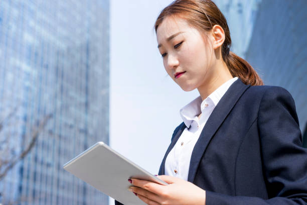 istock young business woman using tablet PC in city 938388896