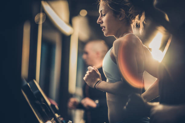 スポーツ ・ フィットネス センターでトレーニング中にトレッドミルで実行されている運動の女性。 - treadmill gym health club exercising ストックフォトと画像