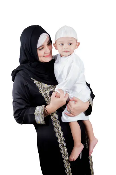 Arabian woman looks happy while holding her son, isolated on white background