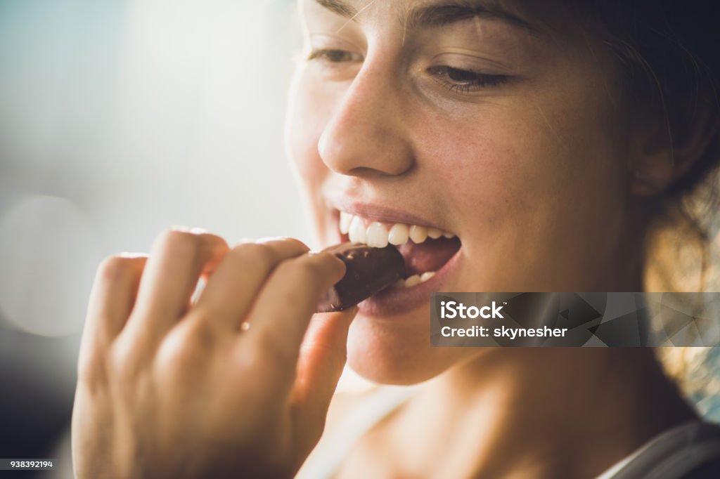 Perto de uma mulher feliz comendo chocolate. - Foto de stock de Chocolate royalty-free