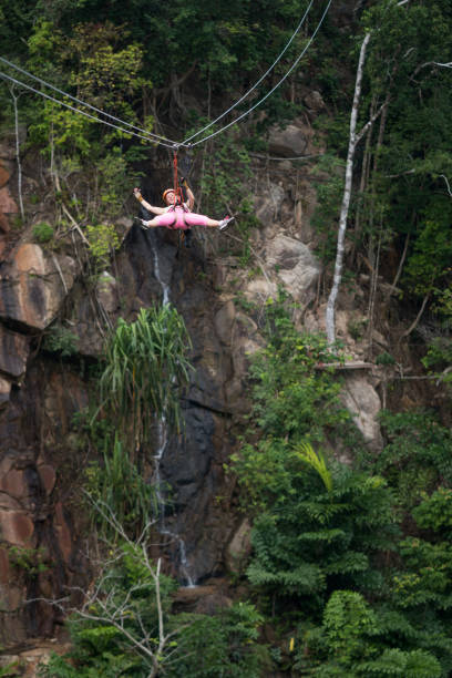 istock Young happy woman having fun while rappelling from a zip line in nature. 938395168