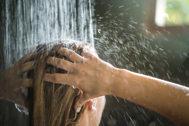 close up van onherkenbaar vrouw wassen van haar haren onder de douche. - douchen stockfoto's en -beelden