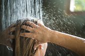 Close up of unrecognizable woman washing her hair under the shower.