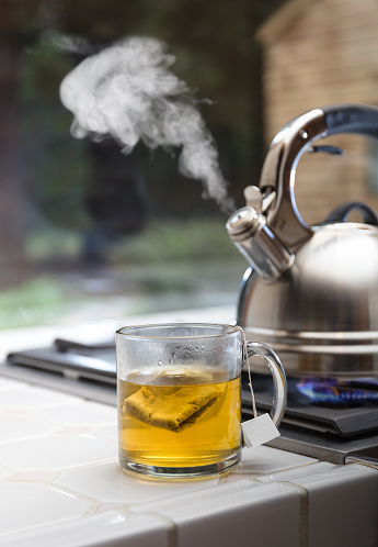 Tea Kettle with Steam on top of a stove