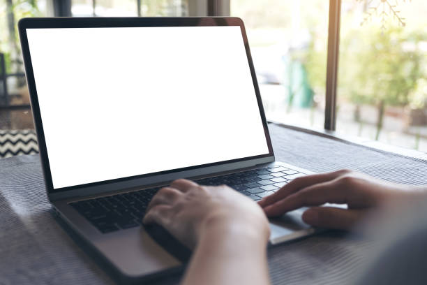 istock Mockup image of a hand using and touching laptop with blank white desktop screen on table in cafe 938399672