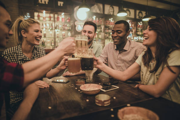 istock Cheerful friends having fun while toasting with beer during their night out in a bar. 938400820