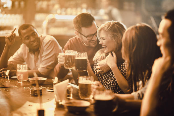 istock Happy couple having fun with their friends in a pub. 938401012