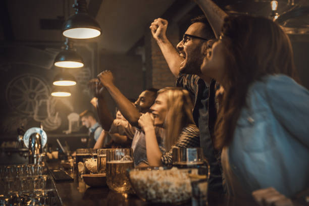 istock Young excited fans having fun in a bar while cheering for their favorite team. 938403918