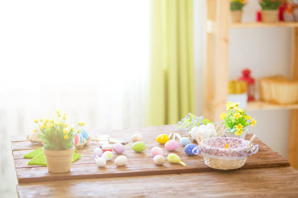 istock Colorful easter eggs and brushes on wooden table in home 938405304