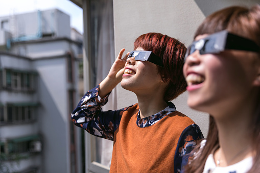 Friends looking at the solar eclipse for the first time