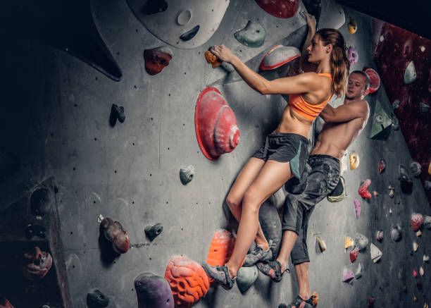istock Male and female climbing on a climbing  wall. 938406010