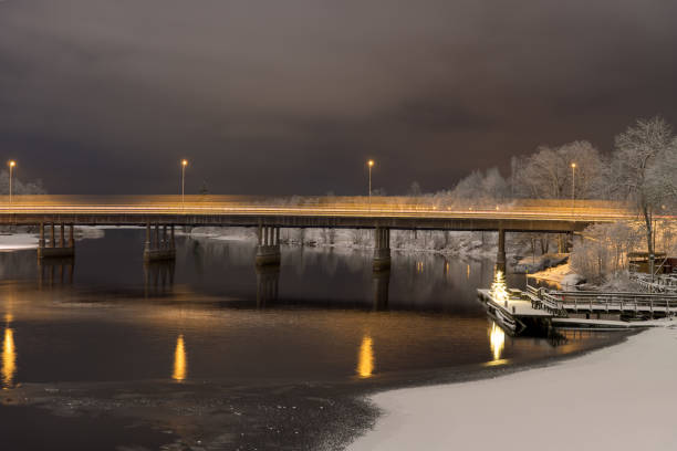 Night view of traffic crossing a concrete bridge  across a river stock photo