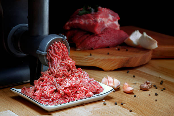 minced meat coming out from grinder. healthy homemade minced meat. dark background. horizontal view photo. place for copyspace. - grinding imagens e fotografias de stock