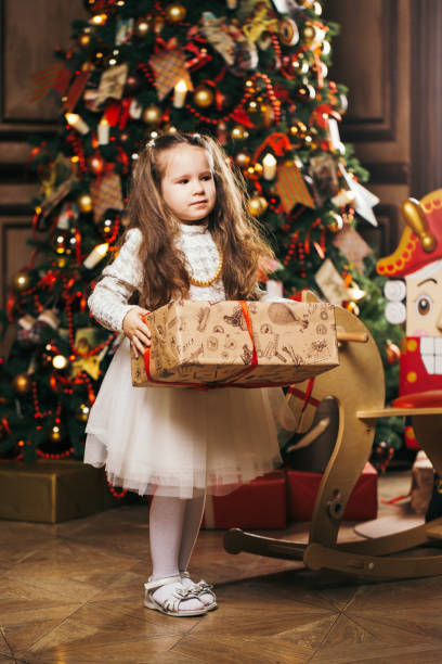 istock Cute little girl standing near Christmas tree and nutcracker 938417716