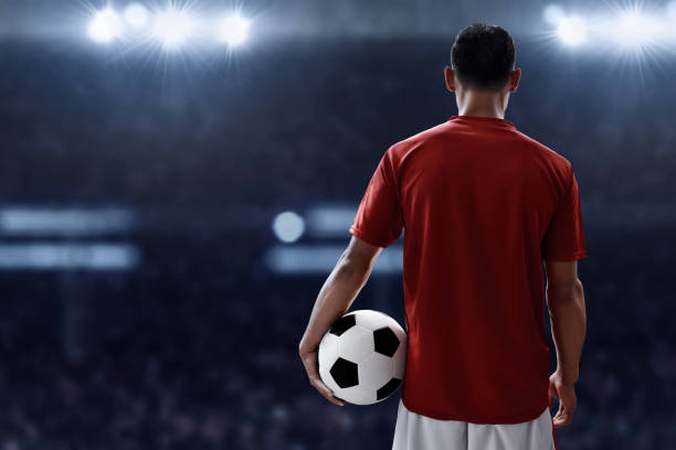 Soccer player holding soccer ball stock photo