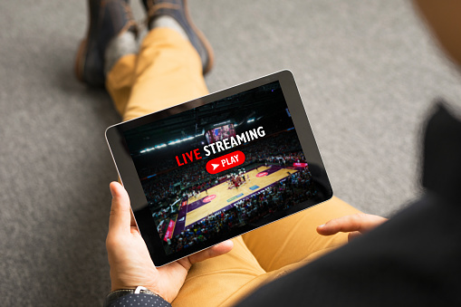 Unrecognisable male watching sports on live streaming online service, view from above