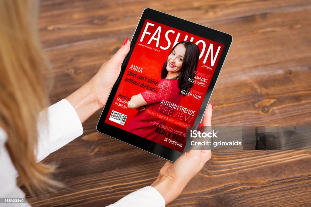 Woman reading fashion magazine on tablet Unrecognisable female reading fashion magazine on tablet computer, view from above Magazine - Publication Stock Photo
