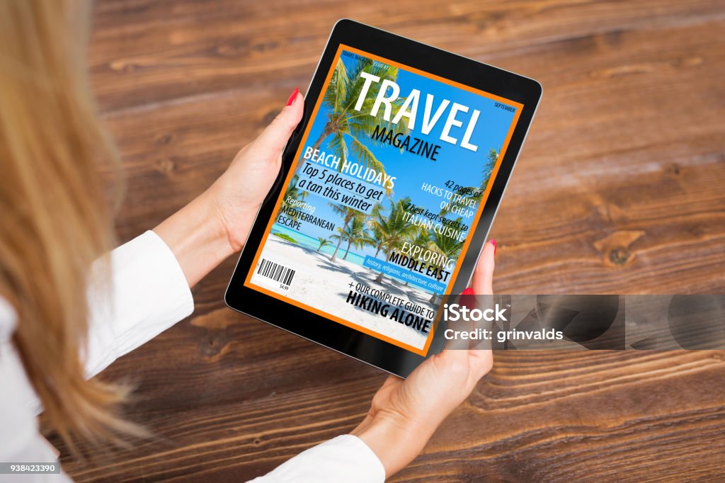 Woman reading travel magazine on tablet Unrecognisable female reading travel magazine on tablet computer, view from above Magazine - Publication Stock Photo