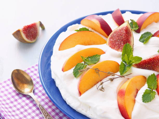 Traditional Pavlova dessert decorated with figs and other summer fruits.