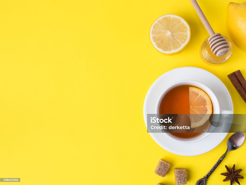 Plat poser sur le pot de cassonade de thé noir citron cannelle anis étoilé fond lumineux jaune de miel Copy space - Photo de Thé - Boisson chaude libre de droits