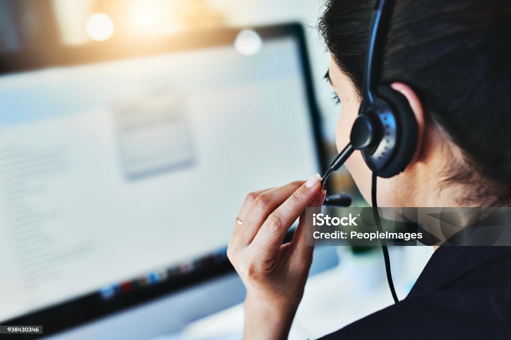 Managing the day's inquiries Rearview shot of a young woman working in a call centre Customer Service Representative Stock Photo