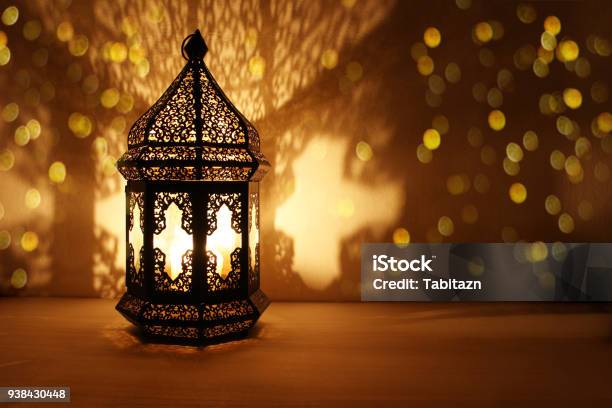 Ornamental Arabic Lantern With Burning Candle Glowing At Night And Glittering Golden Bokeh Lights Festive Greeting Card Invitation For Muslim Holy Month Ramadan Kareem Dark Background Stock Photo - Download Image Now