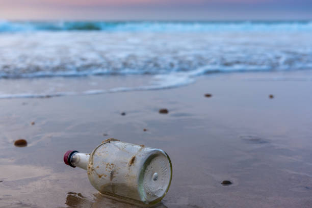 istock A bottle in the sea, on the sand. 938438628