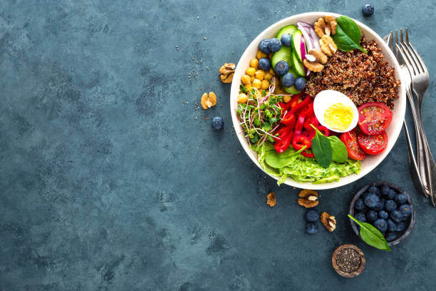 istock Buddha bowl dinner with boiled egg, chickpea, fresh tomato, sweet pepper, cucumber, savoy cabbage, red onion, green sprouts, spinach leaves, blueberry, walnuts, chia and quinoa. Healthy dish, lunch bowl. Detox diet. Balanced food. Top view 938448960