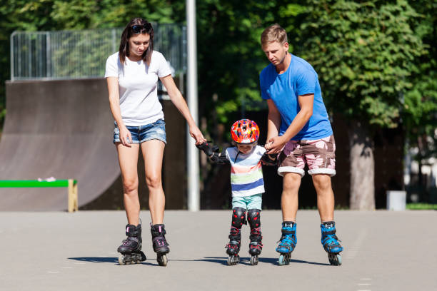 istock Cute baby boy and his mom learning inline skating with skating instructor. 938454776